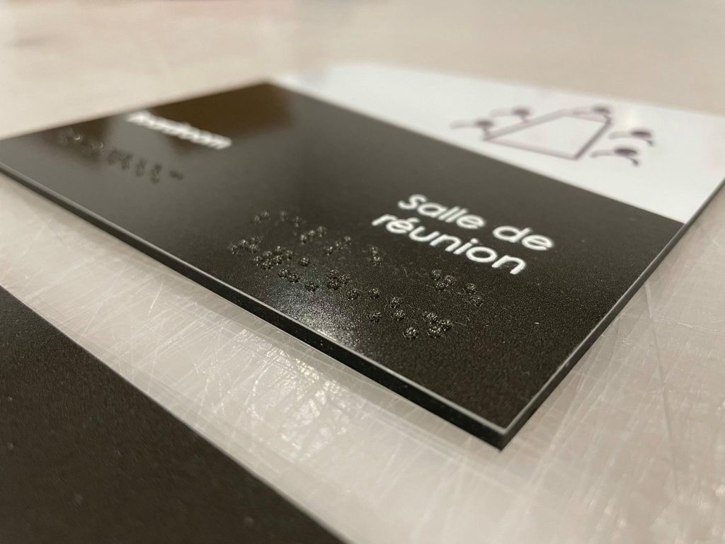 A close-up shot of a business card with "Salle de réunion" elegantly foil-stamped in silver.